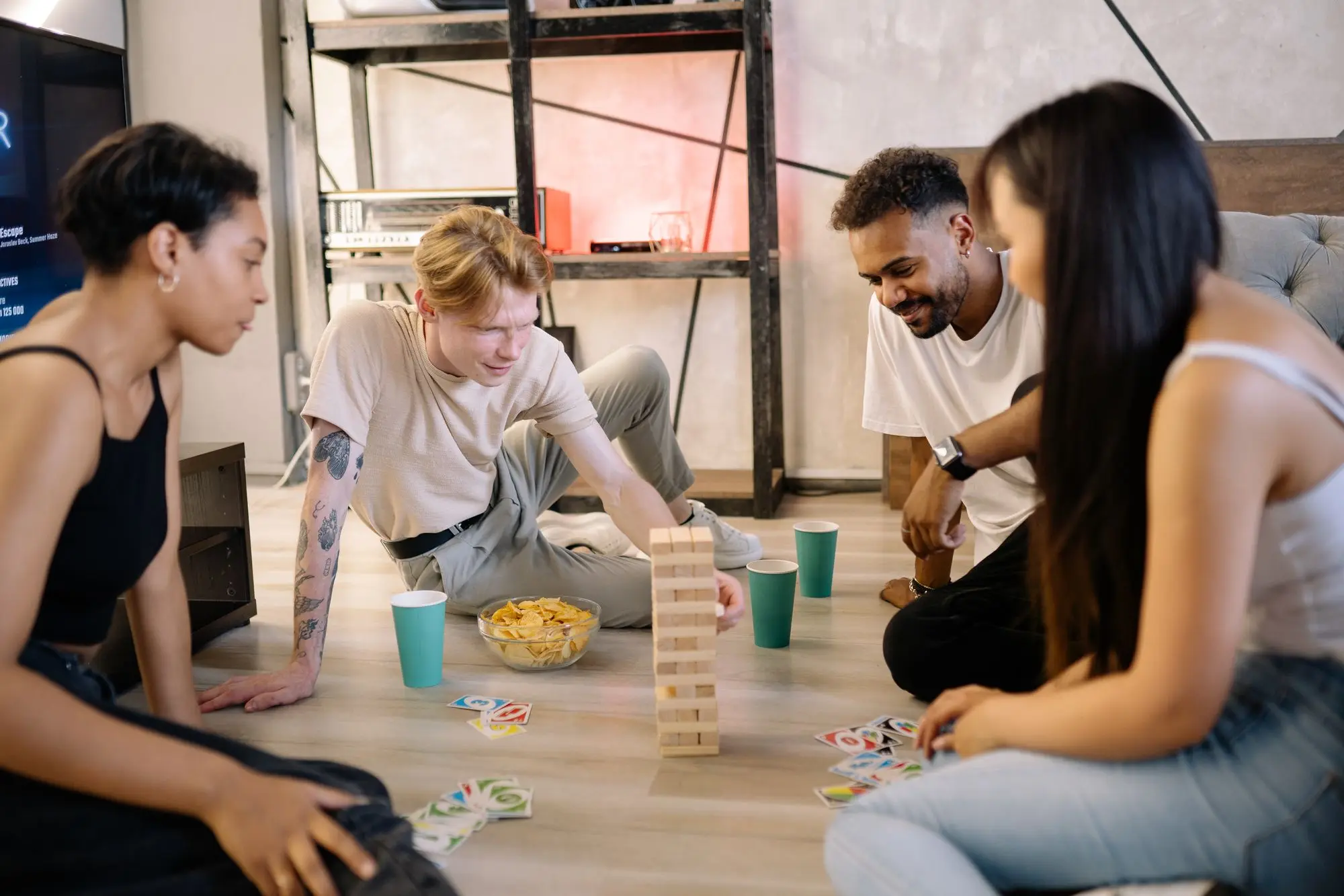 Friends laughing around a stacking-block game